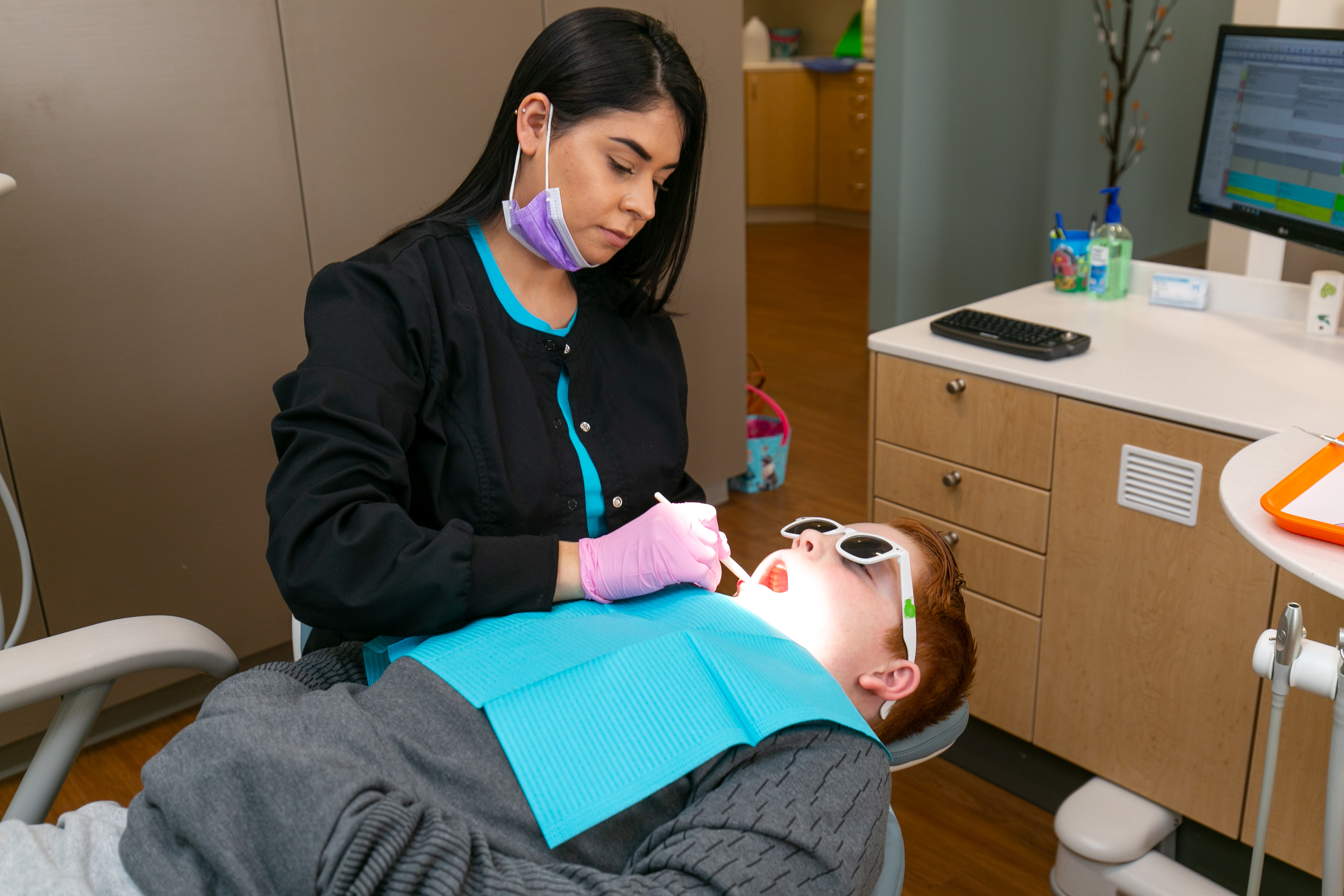 Photo of Teen Patient Receiving Dental Hygiene Check